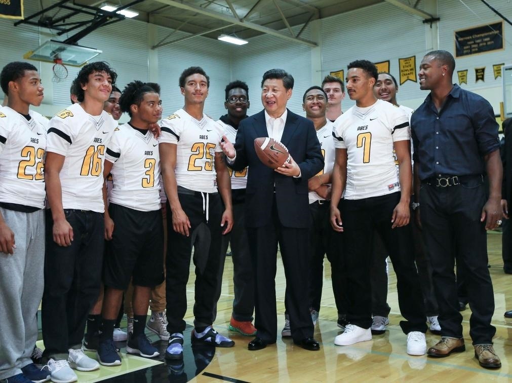 2015年9月23日，國(guó)家主席習(xí)近平參觀美國(guó)塔科馬市林肯中學(xué)。這是習(xí)近平在學(xué)校體育館，同上橄欖球訓(xùn)練課的學(xué)生們親切交談。新華社記者 蘭紅光 攝