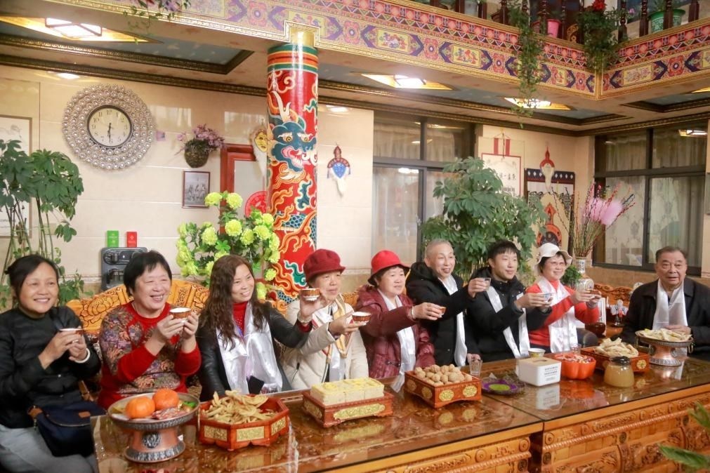游客們?nèi)胱∶袼藓?，舉杯共飲酥油茶。新華社記者 邱星翔 攝