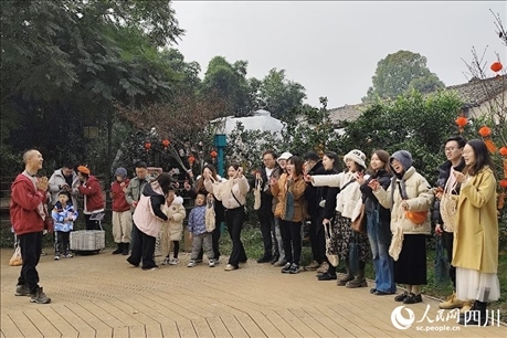 葉科（左一）給前來參與活動的“柑爸柑媽”介紹生態(tài)種植果。人民網記者朱虹攝