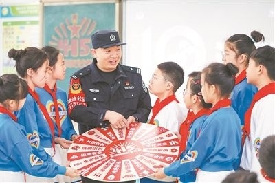 圖為公安民警給學(xué)生們講解國(guó)家安全知識(shí)。張鷹攝