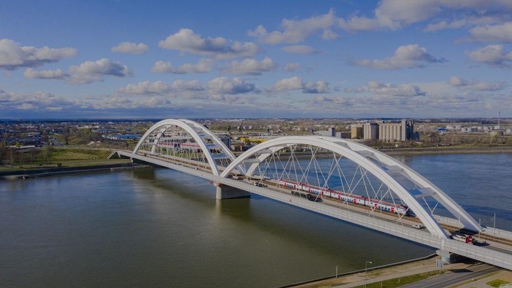 2024年3月12日，一列火車運(yùn)行在匈塞鐵路塞爾維亞境內(nèi)貝諾段諾維薩德多瑙河大橋上（無人機(jī)照片）。新華社發(fā)（任衛(wèi)云攝）