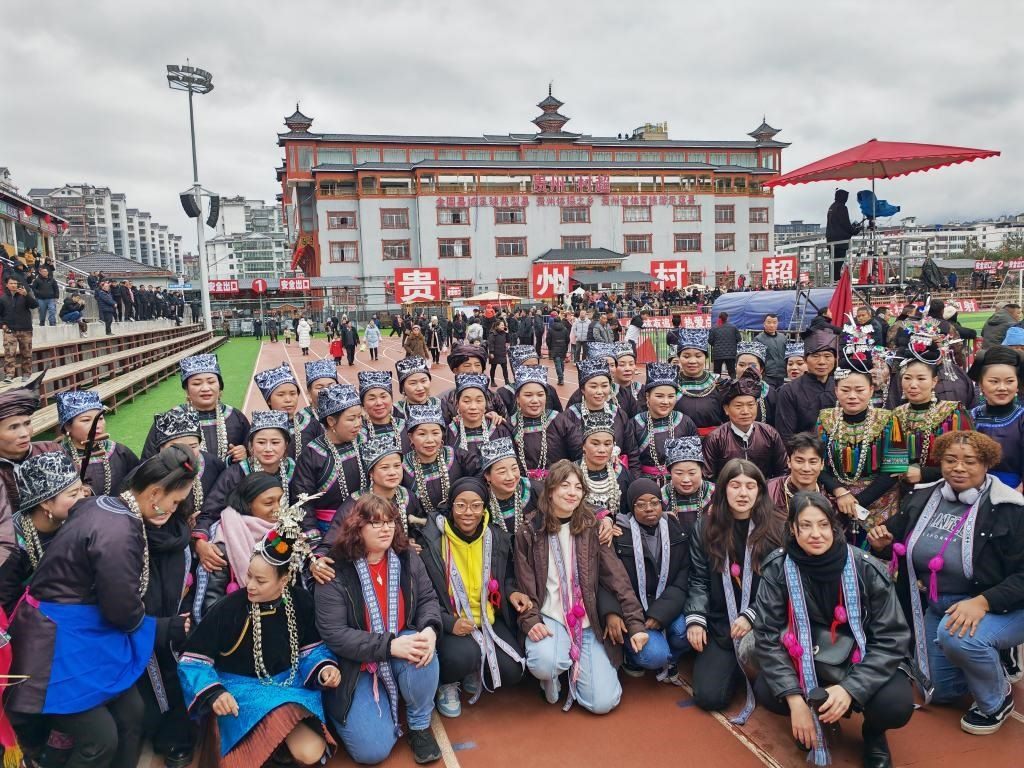 法國(guó)青年在“村超”賽場(chǎng)邊與參加表演的村民合影。新華社記者 羅羽 攝