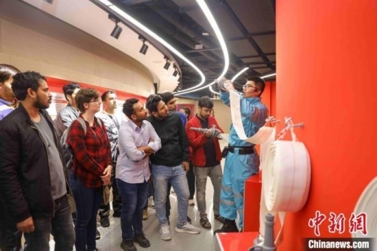 5月9日，工作人員指導(dǎo)留學(xué)生正確使用消防水帶。張鷹 攝