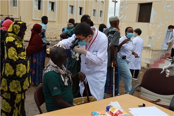 在義診現(xiàn)場，中國醫(yī)生與當(dāng)?shù)鼐用窈嫌傲裟?，吉布提鹽業(yè)投資公司供圖