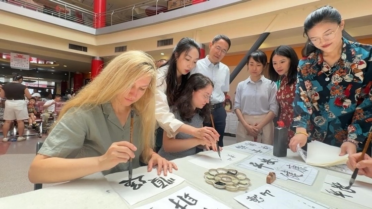 羅馬尼亞友人在活動(dòng)現(xiàn)場(chǎng)學(xué)寫漢字。中國(guó)駐羅馬尼亞大使館領(lǐng)僑處供圖