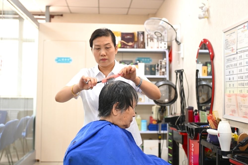 6月20日，長(zhǎng)城花園社區(qū)的志愿者為居民理發(fā)。