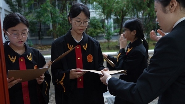 圖①：武平法院干警向?qū)W生分發(fā)道具卷宗。