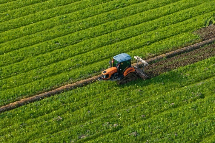 2024年3月19日，在湖南省常德市鼎城區(qū)謝家鋪鎮(zhèn)港中坪村，村民駕駛農(nóng)機(jī)翻耕田地（無(wú)人機(jī)照片）。新華社記者 陳思汗 攝
