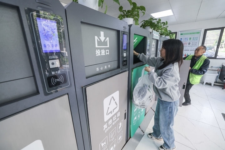 2024年4月10日，在浙江省湖州市吳興區(qū)飛英街道新華府小區(qū)內(nèi)，居民在垃圾分類智能系統(tǒng)的指導(dǎo)下進(jìn)行垃圾分類投放，居民的投放情況將實(shí)時(shí)匯總到智慧服務(wù)平臺(tái)，會(huì)有相應(yīng)的積分獎(jiǎng)勵(lì)。新華社記者 徐昱 攝