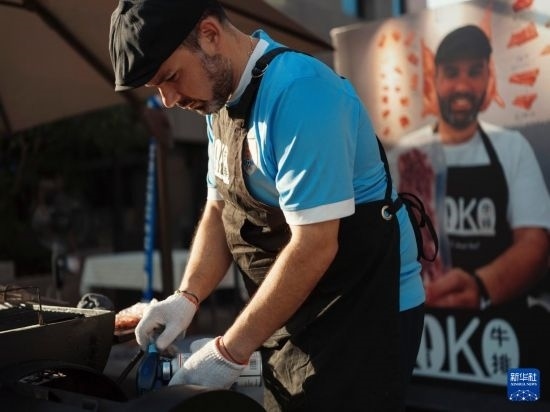 7月19日，在蕪湖古城，馬丁在當(dāng)天舉行的啤酒節(jié)上制作牛排。新華社發(fā)（繆雨晨 攝）