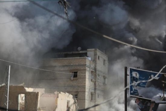 7月21日，在加沙地帶中部的努賽賴特難民營(yíng)，遭以軍空襲的建筑冒出滾滾濃煙。新華社發(fā)（馬爾萬(wàn)·達(dá)烏德攝）