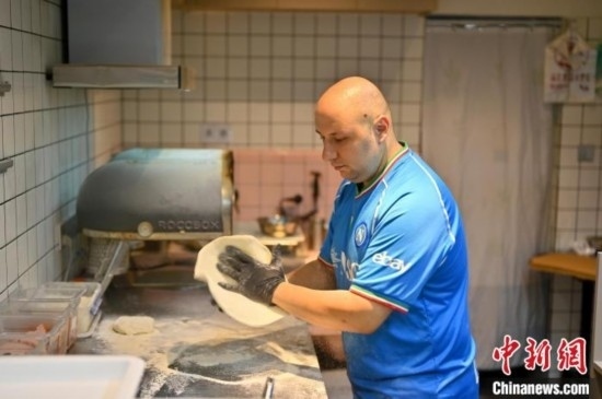 近日，韋榮耀在自家披薩小店內(nèi)忙活。俞靖 攝