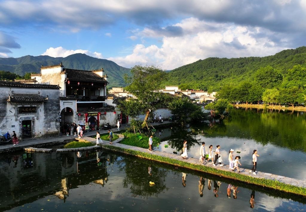 2024年7月7日，游客在安徽省黃山市黟縣宏村游玩。新華社記者杜宇攝