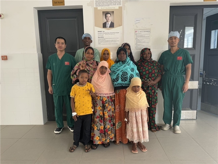 李廣（右一）和王林醫(yī)生與部分患者合影。中國援桑醫(yī)療隊供圖