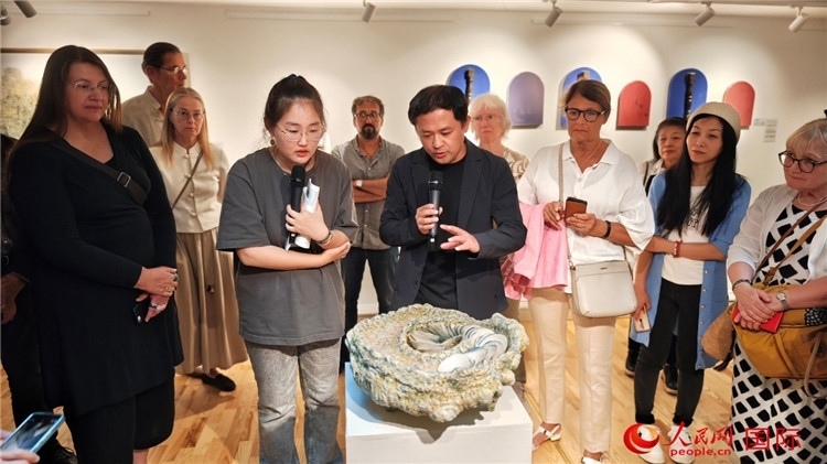 參展人、景德鎮(zhèn)陶瓷大學(xué)設(shè)計(jì)藝術(shù)學(xué)院副院長余劍峰（中）向來賓介紹參展作品。人民網(wǎng)記者 殷淼攝