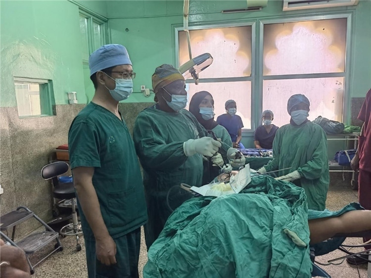 隊(duì)長蔣國慶（左一）關(guān)注當(dāng)?shù)蒯t(yī)生手術(shù)情況。中國援桑醫(yī)療隊(duì)供圖