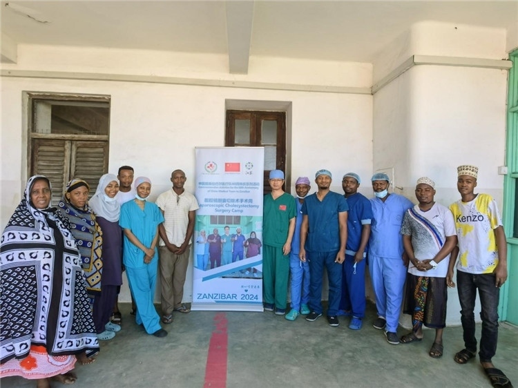 隊(duì)長蔣國慶（右七）和手術(shù)醫(yī)生、部分患者合影。中國援桑醫(yī)療隊(duì)供圖