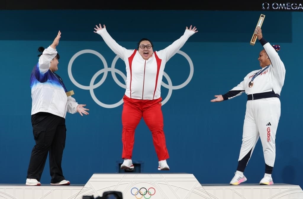 中國選手李雯雯（中）在巴黎奧運會舉重女子81公斤以上級頒獎儀式中登上領(lǐng)獎臺（2024年8月11日攝）。新華社記者 楊磊 攝