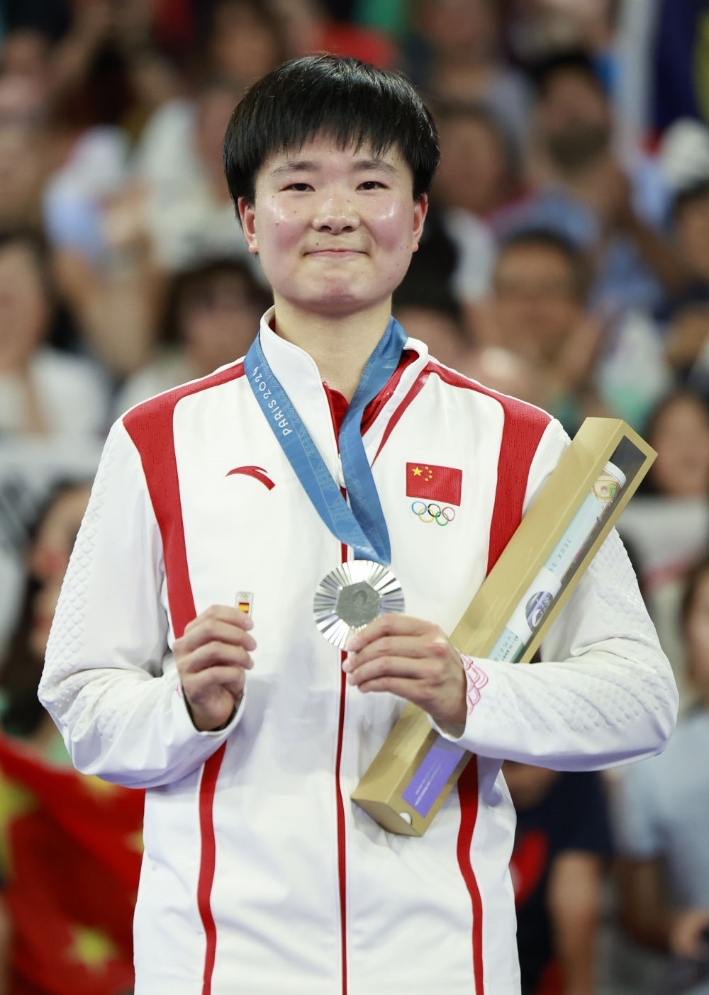 巴黎奧運會羽毛球女子單打亞軍、中國選手何冰嬌在頒獎儀式上一手握著銀牌，一手握著西班牙奧委會徽章（2024年8月5日攝）。新華社記者 任正來 攝