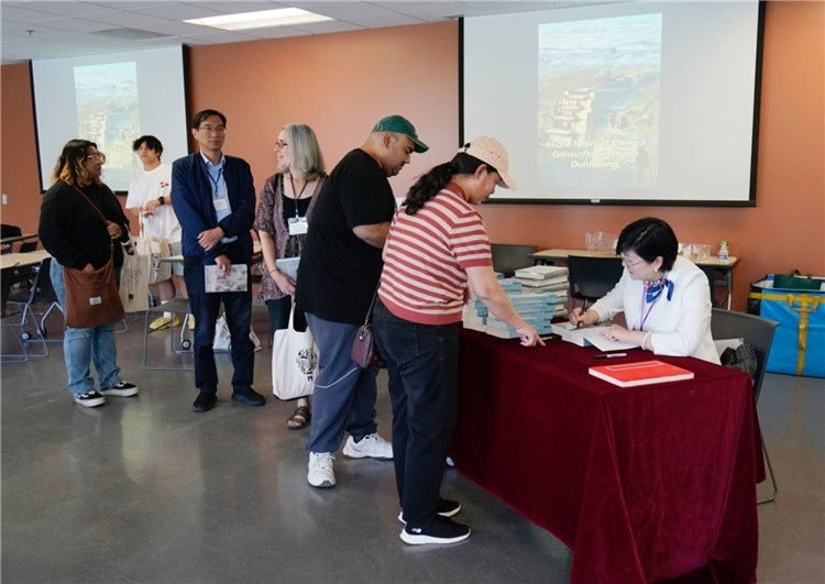 作者顧春芳在活動現(xiàn)場簽名贈書。羅先勇攝