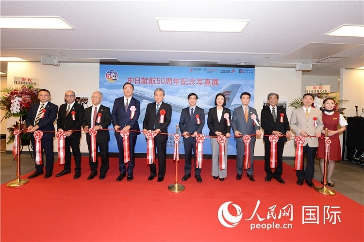 與會嘉賓共同為中日通航50周年紀(jì)念圖片展開幕剪彩。馮學(xué)敏攝