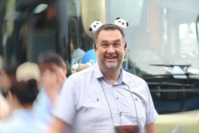 參訪熊貓谷前，塞爾維亞“一帶一路”研究所所長博揚(yáng)·拉利奇戴上熊貓頭飾。（李佩藺 攝）