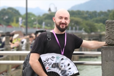 俄羅斯塔斯社執(zhí)行編輯葉夫根尼·扎多羅日內(nèi)在都江堰魚嘴拍照留念。（李佩藺 攝）