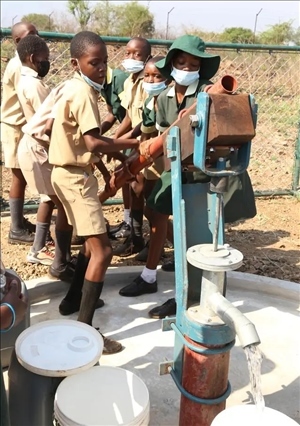 △2021年11月，在津巴布韋南馬塔貝萊蘭省省會(huì)關(guān)達(dá)的塞農(nóng)多小學(xué)，學(xué)生從中國(guó)援建水井里打水。