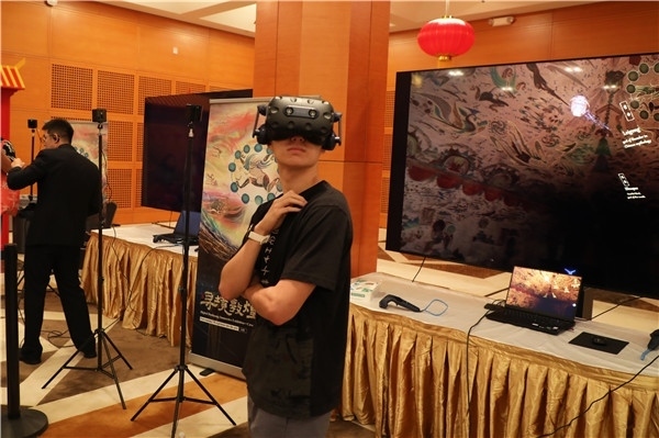 1、在本次活動的展覽現(xiàn)場，敦煌研究院與騰訊展示了“數(shù)字藏經洞”和“尋境敦煌”等創(chuàng)新互動產品。圖為當?shù)孛癖娡ㄟ^VR虛擬游覽洞窟。 人民網記者 李志偉攝