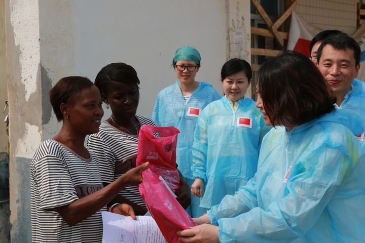 2015年4月4日，在位于塞拉利昂首都弗里敦市郊的中塞友好醫(yī)院埃博拉診療中心，中國第四批援塞醫(yī)療隊副隊長邵蔚（右前）向被治愈的埃博拉出血熱患者贈送禮物。新華社發(fā)（祖榮強 攝）