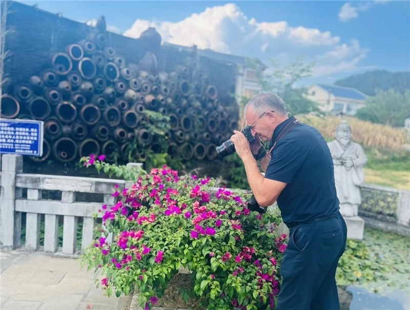 遠(yuǎn)處黔北民居錯(cuò)落有致，近處一只黑色的蝴蝶穿梭于粉紫色三角梅花叢間隙，與俄羅斯“大歐亞”總編輯弗拉基米爾·別列日內(nèi)赫的鏡頭玩起了捉迷藏，“你追我逃，不亦樂(lè)乎”。（張亞欣攝）