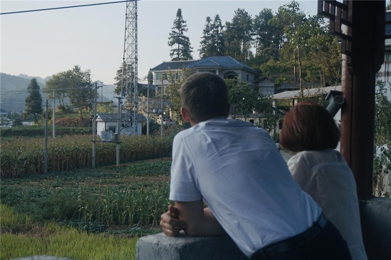 望得見(jiàn)山，看得見(jiàn)水，記得住鄉(xiāng)愁。每個(gè)人心中都有一個(gè)屬于自己的“花茂村”，在這方心田，走遍千山萬(wàn)水，鄉(xiāng)音未改鬢毛衰。吉爾吉斯斯坦《比什凱克晚報(bào)》第一副總編輯妮娜·尼奇博洛娃與《中國(guó)與俄羅斯》雜志社社長(zhǎng)奧列格·別列日內(nèi)赫攝在花茂村民居屋檐下并肩佇立，眺望山水，尋覓鄉(xiāng)愁。（李光裕攝）