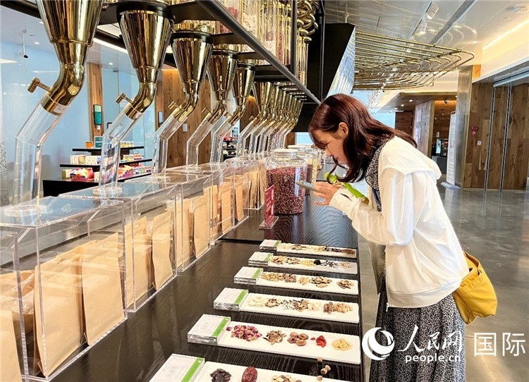 4. 代表團(tuán)團(tuán)員對新中式茶飲的食材充滿興趣。（人民網(wǎng)記者陳思 攝）