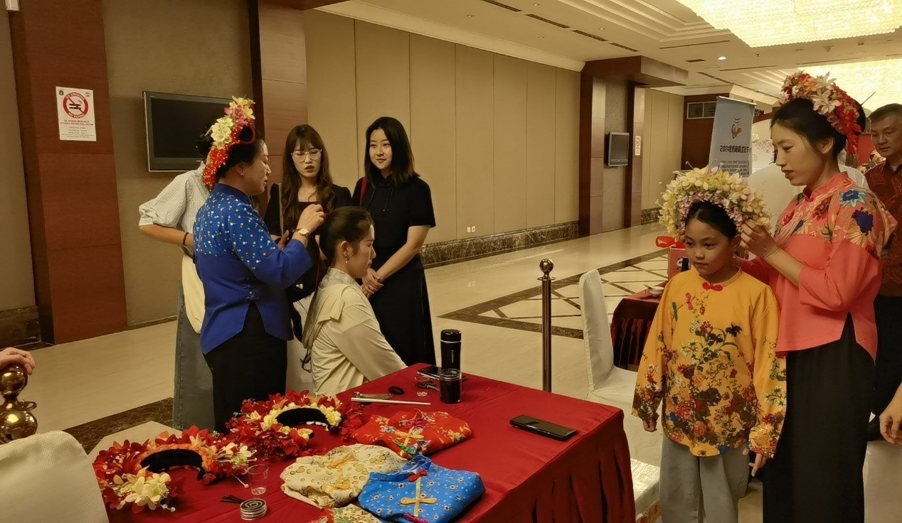 阿拉扎大學(xué)孔子學(xué)院志愿者老師向傳承人學(xué)習(xí)簪花圍。阿拉扎大學(xué)孔子學(xué)院供圖