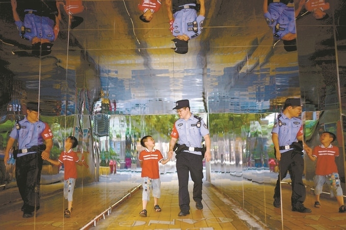 ?7月16日，重慶市公安局江北區(qū)分局一名民警在巡邏途中遇到一個(gè)獨(dú)自玩耍的小男孩，民警將其送回家。王洪平攝