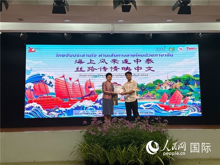 中國駐泰國大使館一等秘書王歡（左）為一等獎獲獎?wù)哳C獎