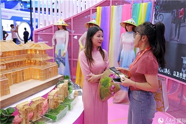 參觀者在東博會(huì)越南展區(qū)同工作人員咨詢交談。人民網(wǎng)記者 趙益普攝