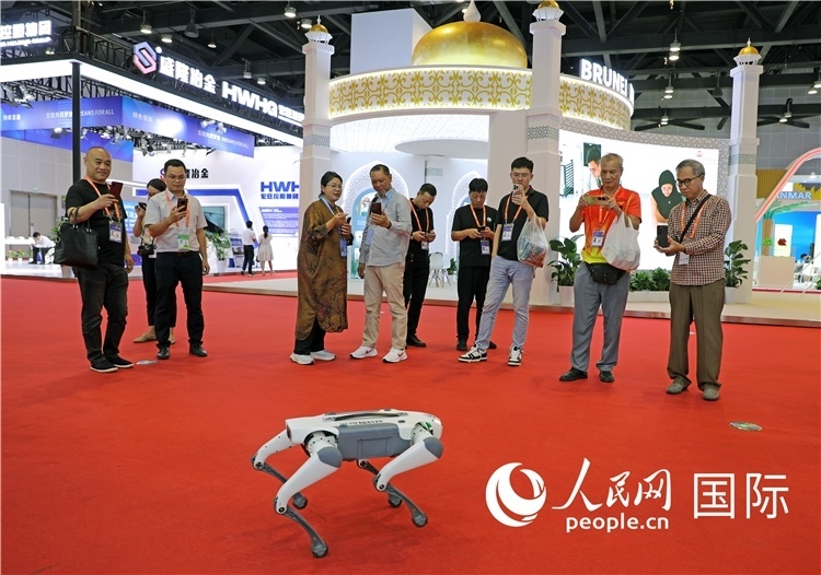 東博會(huì)上，觀眾正在參觀一只機(jī)器狗。綠色能源、新能源汽車、綠色農(nóng)產(chǎn)品等成為本屆東博會(huì)觀眾關(guān)注的焦點(diǎn)。人民網(wǎng)記者 趙益普攝