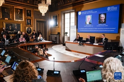 10月8日，在瑞典斯德哥爾摩舉行的2024年諾貝爾物理學(xué)獎公布現(xiàn)場，屏幕顯示獎項(xiàng)得主美國普林斯頓大學(xué)的約翰·霍普菲爾德和加拿大多倫多大學(xué)的杰弗里·欣頓。新華社記者 彭子洋 攝