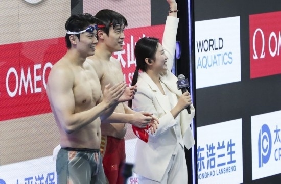  10月18日，汪順（左）和潘展樂在男子100米混合泳決賽后。新華社記者 方喆 攝