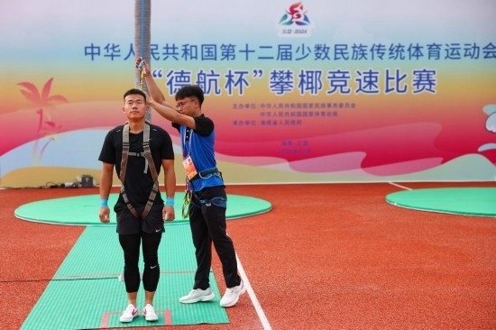 11月23日，工作人員為上海隊選手付樂樂（左）系安全繩。新華社記者 楊植森 攝