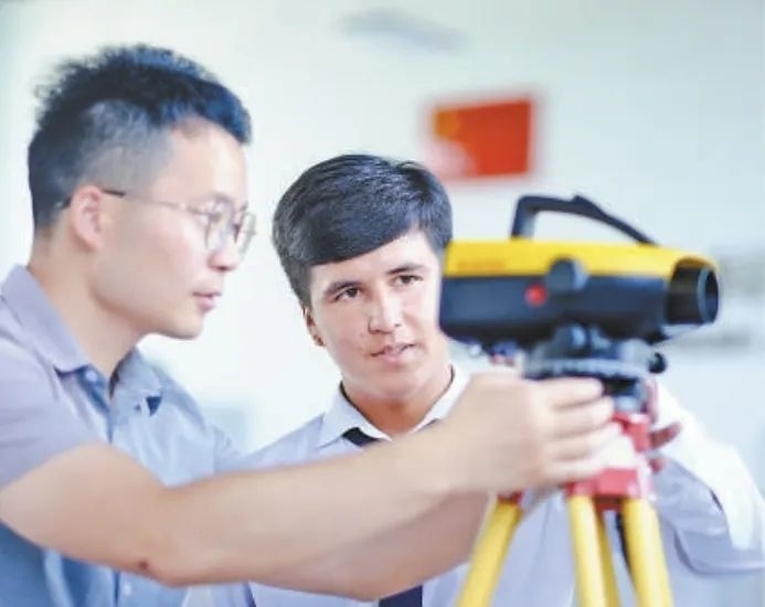 在塔吉克斯坦首都杜尚別的魯班工坊，來自天津城市建設(shè)管理職業(yè)技術(shù)學院的老師（左）為當?shù)貙W生提供指導。新華社記者 鄭開君 攝