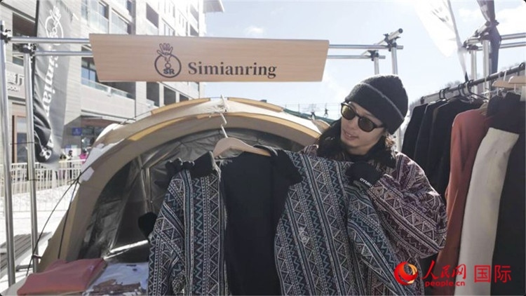 藤田周正在展示自己設(shè)計(jì)的滑雪服。人民網(wǎng)記者 袁蒙攝