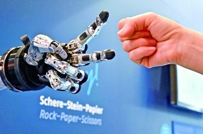 在德國(guó)漢諾威工博會(huì)上，參觀者與一款智能機(jī)器人進(jìn)行“石頭剪子布”游戲。新華社發(fā)