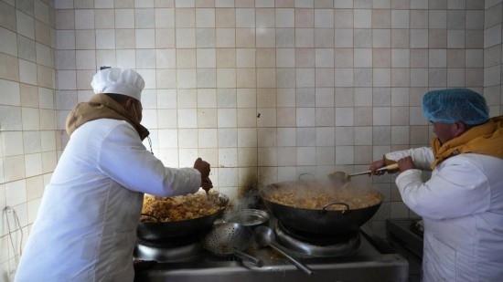 1月14日，服務(wù)隊(duì)的兩名廚師正在為村民們做午飯。新華社記者 邱星翔 攝