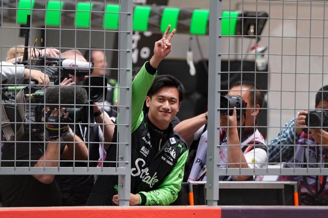 2024年4月19日，索伯車隊中國車手周冠宇（中）在練習(xí)賽前向觀眾致意。當(dāng)日，F(xiàn)1中國大獎賽在上海開賽。中國車手周冠宇主場首秀參賽。新華社記者 夏一方攝