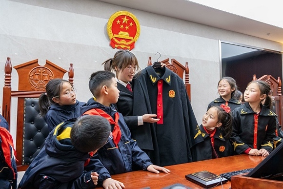 圖②：干警向同學們介紹法袍。