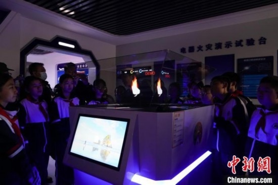 圖為學生們參觀道里區(qū)消防救援大隊消防科普體驗館內幻影成像燃燒三要素實驗臺。中新社記者 趙宇航 攝