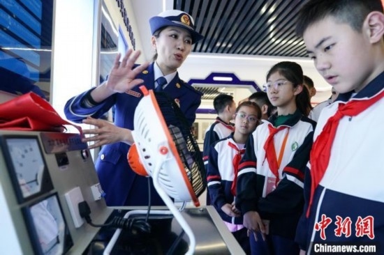 圖為學生們參觀道里區(qū)消防救援大隊消防科普體驗館內電器火災演示實驗臺。中新社記者 趙宇航 攝