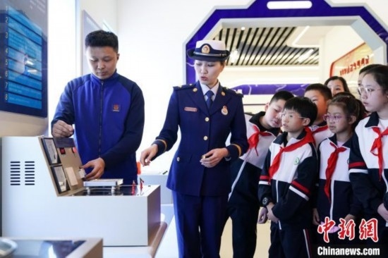 圖為學生們參觀道里區(qū)消防救援大隊消防科普體驗館內電器火災演示實驗臺。中新社記者 趙宇航 攝